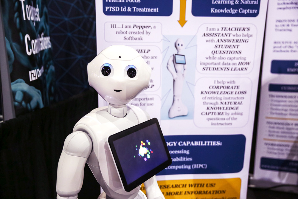 A white robot in front of a poster.